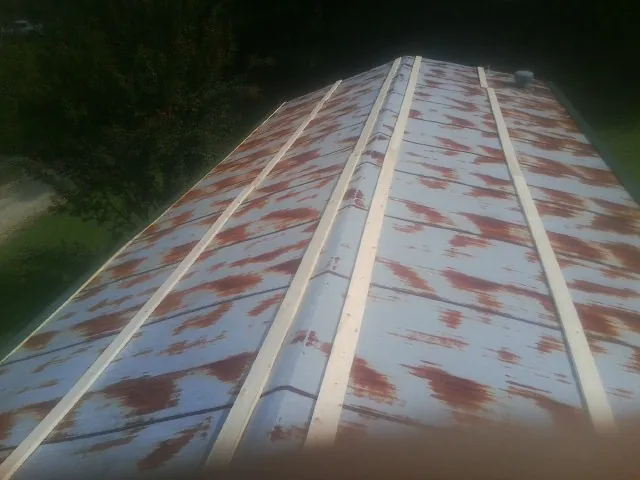 Rusted metal roof panels with new wood purlins before replacement — Storm Damage Roof Repair in Maxton by Roofing Brothers