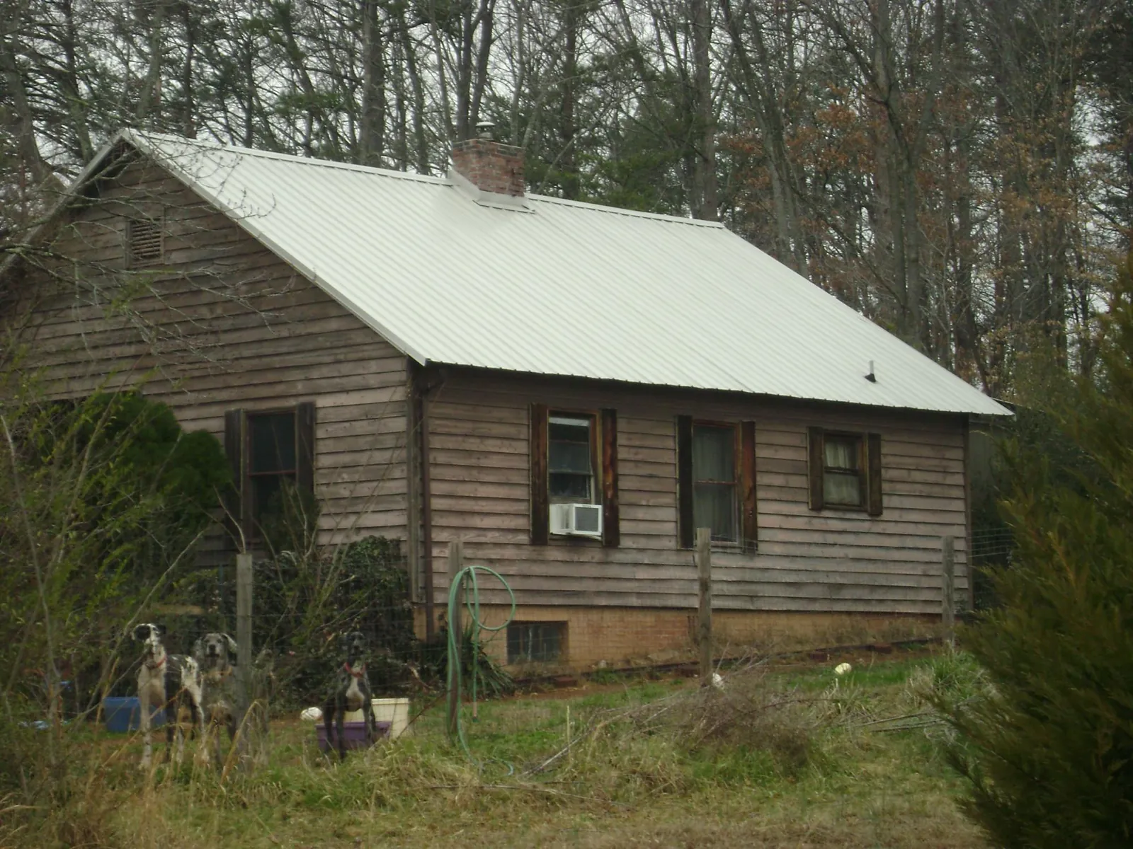 White metal roof on an old wood sided farmhouse, from a Metal Roof Installation job in Maxton